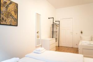 柏林Great Apartment for Eight in Berlin Neukölln的白色的客房配有两张床和镜子