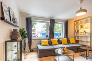 汉堡3 Bedroom apartment in great location的客厅配有灰色的沙发和黄色的枕头。