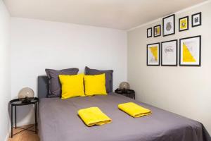 柏林Loft Apart plus AC plus SelfCheckIn的一间卧室配有一张带黄色枕头的大床