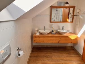 贡岑豪森Posthotel Arnold的浴室设有2个水槽和镜子