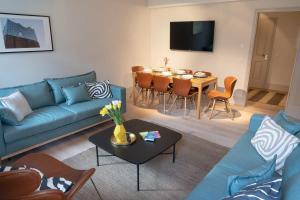 汉堡Spacious 3-bedroom apartment near Eilbekpark的客厅配有蓝色的沙发和桌子