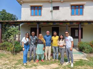 BhurkīāBardiya Eco Safari Homestay的一群站在房子前面的人