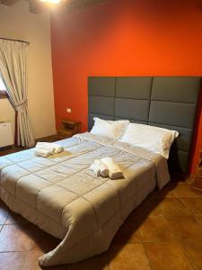 PolazzoLa corte dell'ulivo的一间卧室配有一张大床和毛巾