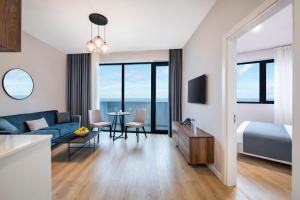 巴统STEPS Batumi Hotel & Suites的酒店客房配有蓝色的沙发、床和桌子。