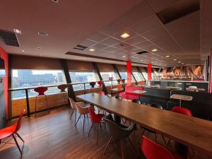 格拉茨BEST IN HOSTING Graz的一间设有红色桌椅的餐厅和一间酒吧