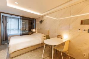 首尔Wecostay Gangnam的酒店客房配有一张床铺和一张桌子。