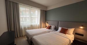 布达佩斯Escala Hotel & Suites的酒店客房设有两张床和窗户。
