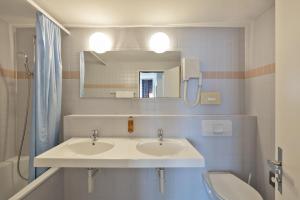 巴塞尔Merian Basel - Self Check-in的浴室设有2个水槽、卫生间和镜子。