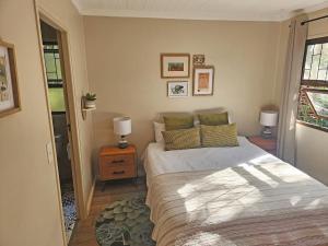 自然谷Nature's Edge Cabin的一间卧室配有一张床和一张带两盏灯的桌子。