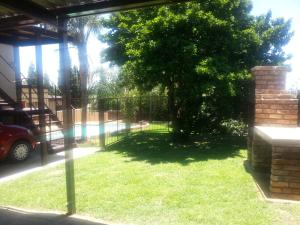 比勒陀利亚Private Apartments & Biz Stays Pretoria的一座有树和栅栏的院子