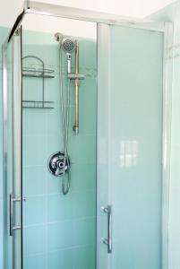 丽都迪奥斯蒂亚La Vittoria的浴室里设有玻璃门淋浴