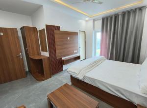 SasarāmAKS INTERNATIONAL HOTEL AND RESORT的一间卧室配有一张床、木制家具和窗户。