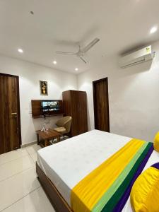 卢迪亚纳THE LUXURY PLATINUM INN --Luxury Deluxe Rooms -- Chandigarh Road的一间卧室配有一张大床和色彩缤纷的毯子