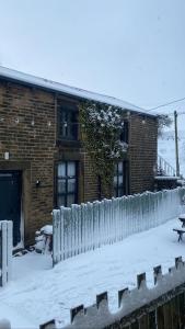 WinewallTrawden Arms Community Owned Pub的建筑物前的雪覆盖的栅栏