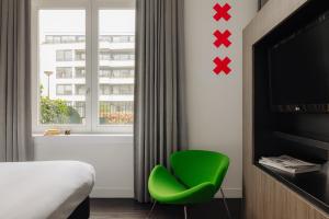 阿姆斯特丹阿姆斯特丹马诺尔酒店的卧室设有一张绿色椅子,靠窗