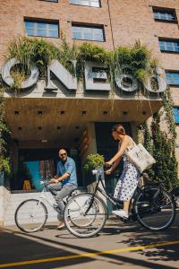 卢布尔雅那ONE66 Hotel的一名男子和一名女子骑着自行车在建筑物前骑行