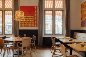 阿姆斯特丹阿姆斯特丹马诺尔酒店的餐厅设有桌椅和窗户。
