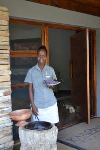 Karongwe Game ReserveKarongwe Portfolio - Becks Safari Lodge的站在门前拿着盘子的女人