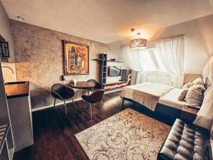 布拉格Alfons Boutique Hotel的卧室配有一张床和一张桌子及椅子