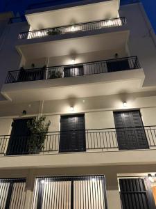 雅典AIONION RESIDENCES by K&K的公寓大楼设有两个带黑色门的阳台