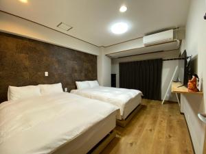 东京浅草・花豆HOTEL的酒店客房设有两张床和电视。