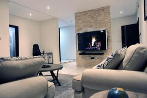 努瓦克肖特Garden Suites的带沙发和平面电视的客厅