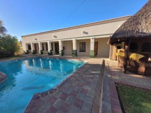 VryburgMolopo Naledi Guest Lodge的大楼前的游泳池