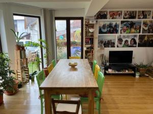 巴亚马雷B&B San Michele的一间带木桌和绿色椅子的用餐室