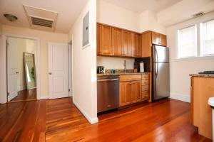 马尔登Stylish Apartment in Malden 20 Min from Boston #2的厨房配有木制橱柜和不锈钢冰箱。