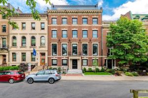 波士顿Modern Studio in Historic Boston - Unit #302的两辆汽车停在一座大型砖楼前