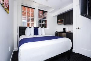 波士顿Modern Studio in Historic Boston - Garden Unit #4的卧室配有带蓝色枕头的大型白色床