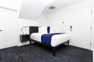 波士顿Stylish Studio in Historic Boston - Unit #405的一间卧室配有一张带蓝白色毯子的床