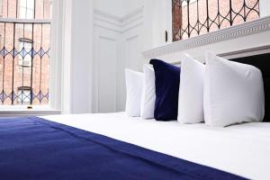 波士顿Luxurious Studio in the Heart of Boston的一张带白色和蓝色枕头的床和窗户