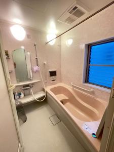 大阪孔雀民宿的带浴缸、水槽和镜子的浴室