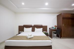 班加罗尔Sanctum Suites BEL Road Bangalore的一间卧室配有一张大床和一张书桌