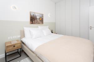特拉维夫HOMEZ- Carmel Market的卧室配有一张白色的大床和床头柜。