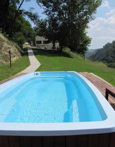 皮亚诺罗Podere Riosto Cantina&Agriturismo的享有房屋景致的甲板上的游泳池
