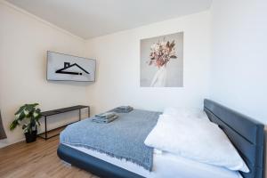 韦尔斯Modernes Apartment Wels City Center, TG-Stellplatz的一间白色客房内的床铺卧室