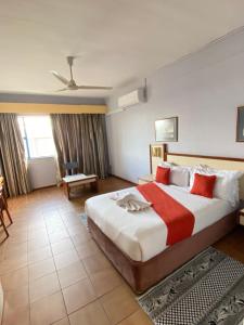 哈博罗内哈博罗内酒店的酒店客房配有一张带红色枕头的大床