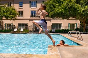 圣罗莎索诺玛酒庄凯悦酒店 的一名女子和一个男孩跳进游泳池