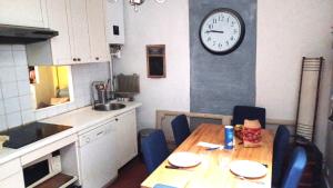 巴黎Marceau的厨房配有桌子和墙上的时钟
