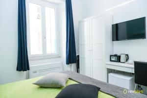 斯培西亚Lia Rooms Cinque Terre Wave的一间卧室配有一张带蓝色窗帘的床和电视。
