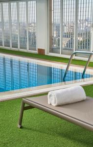 瓦伦西亚NH瓦伦西亚中心酒店的游泳池旁长凳上的毛巾