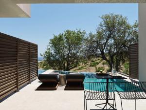 VourvoúlosMagma Resort Santorini, In The Unbound Collection By Hyatt的一个带桌椅的庭院和一个游泳池