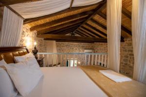 阿里奥波利斯卡缇玛卡拉吉尔格酒店的卧室配有一张白色大床和木制天花板