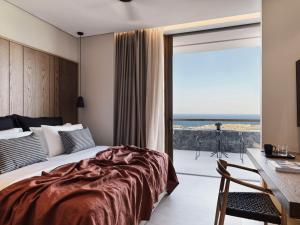 VourvoúlosMagma Resort Santorini, In The Unbound Collection By Hyatt的一间卧室配有一张床,享有海景