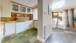 牛津Princes Street的厨房配有白色橱柜和瓷砖地板。