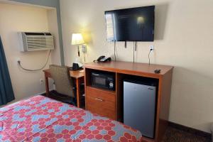 Waite ParkEcono Lodge的酒店客房配有一张床和一张书桌及一台电视