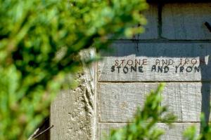 小樽石と鉄-House of STONE and IRON的砖墙边的标志
