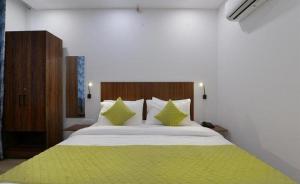 加济阿巴德Hotel The Emporio A Corporate Suites的卧室配有一张带绿床单和枕头的大床。